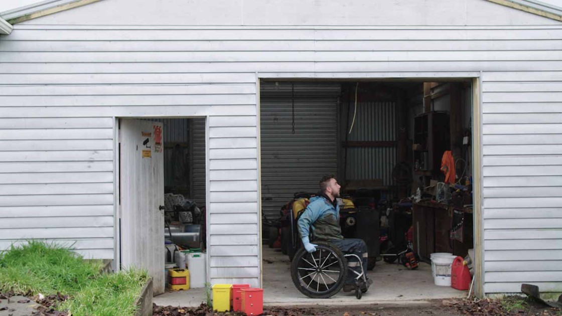 Jack in his wheelchair inside a shed. 