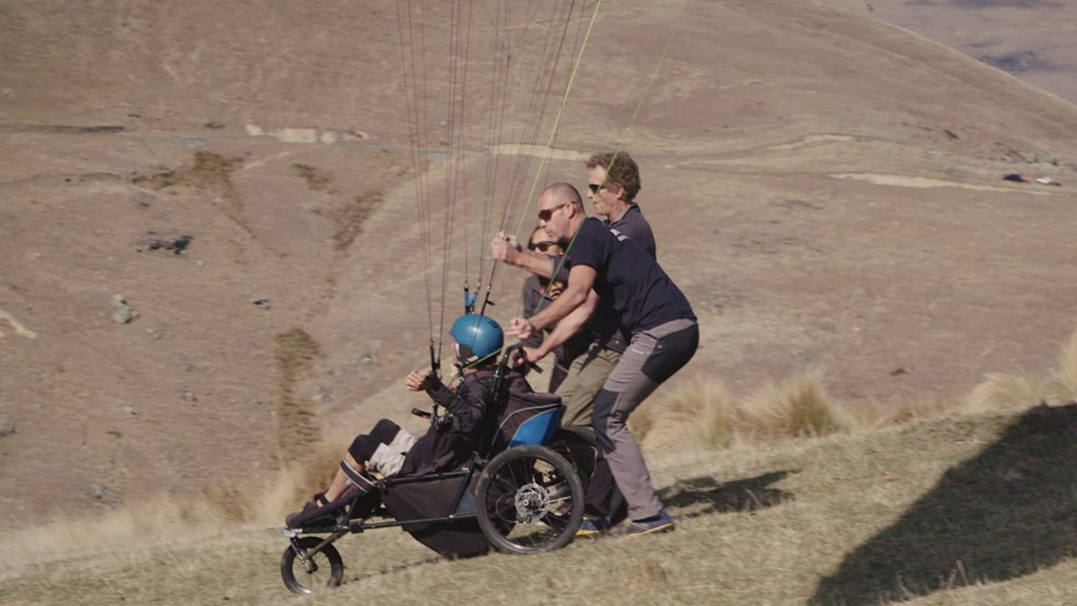 Jezza in a hanglider about to fly of a steep cliff.